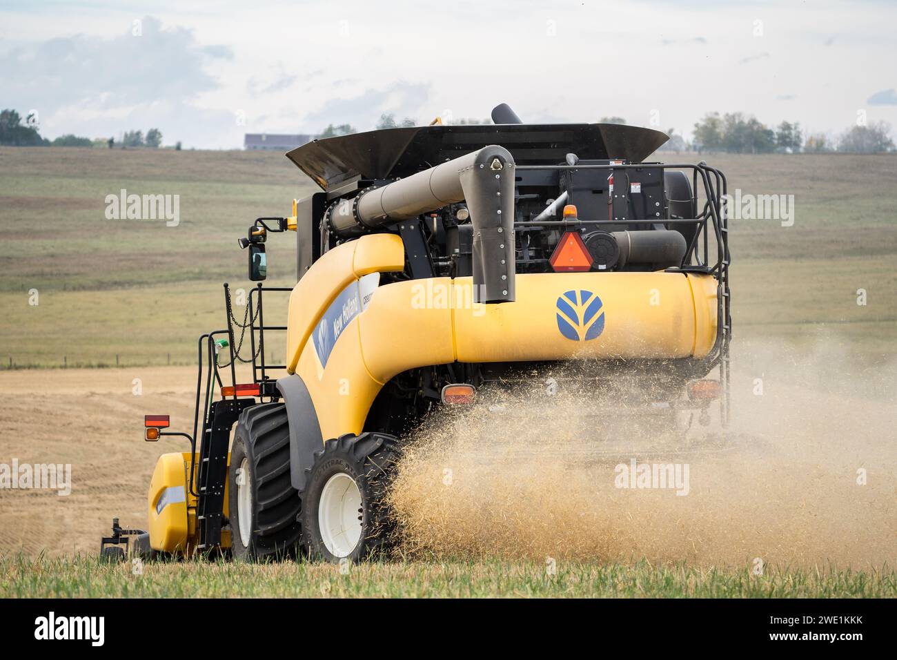 Rocky View County Alberta Canada, 21 settembre 2023: Combine fa una curva durante la raccolta di un raccolto di paraurti con tracce di polvere sulle praterie canadesi Foto Stock