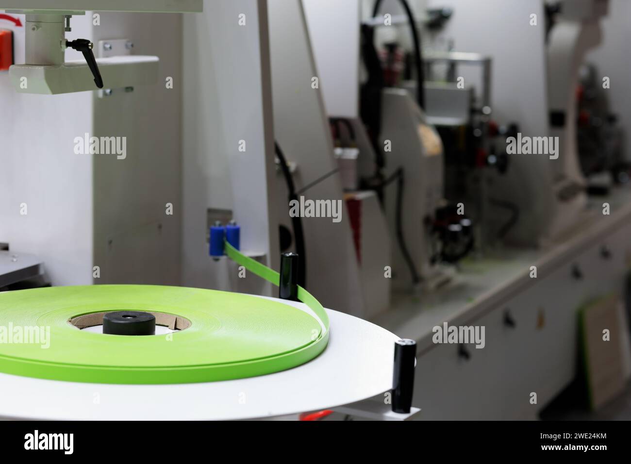 Macchina per bordatura automatica dei bordi con rotolo di nastro per bordatura in PVC da 2 mm. Messa a fuoco selettiva. Foto Stock