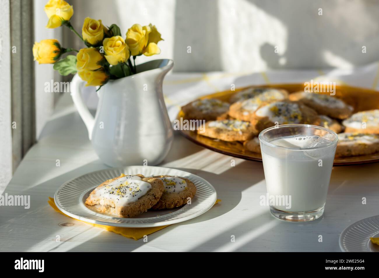 Biscotti freschi fatti in casa a base di semi di limone su un tavolo accanto a una finestra luminosa. Foto Stock