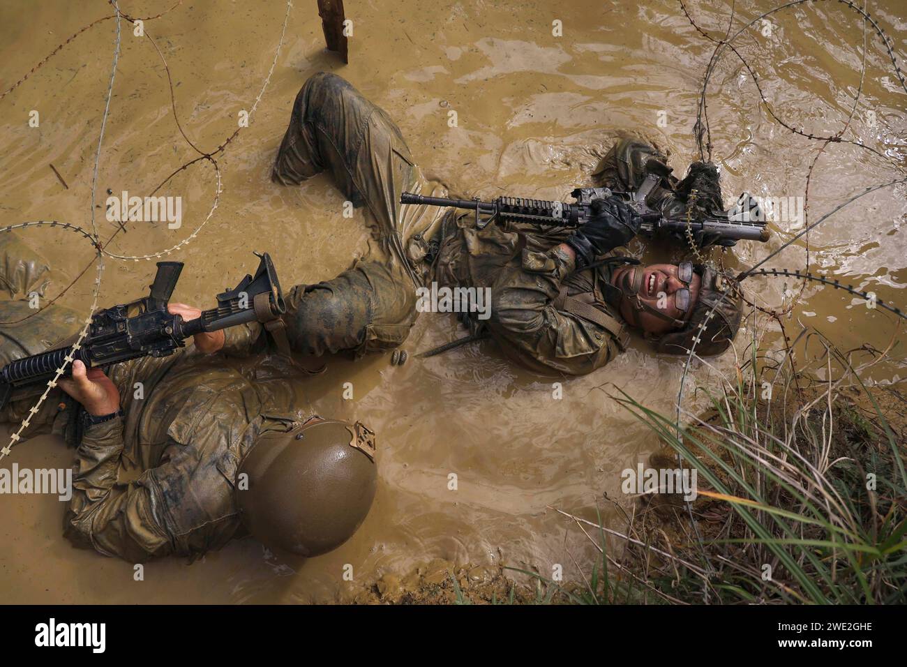 Giappone. 11 gennaio 2024. U.S. Marines with III Marine Expeditionary Force navigate under concertina Wire durante un corso Basic Jungle Skills presso il Jungle Warfare Training Center a Camp Gonsalves, Okinawa, Giappone, gennaio. 12, 2024. BJSC insegna ai Marines abilità di sopravvivenza nella giungla di base, tecniche tattiche di sospensione della corda e tattiche di guerra nella giungla per migliorare la letalità negli ambienti difficili della giungla. (Immagine di credito: © U.S. Marines/ZUMA Press Wire) SOLO USO EDITORIALE! Non per USO commerciale! Foto Stock