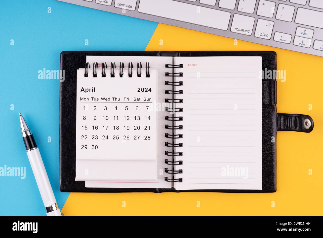 Calendario, blocco note, penna e tastiera del computer aprile 2024 Foto Stock