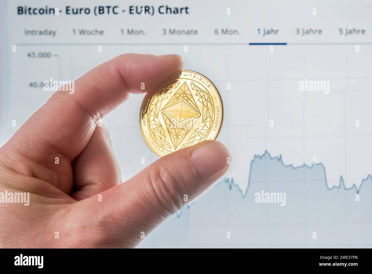 Moneta Ethereum davanti a un grafico Bitcoin Foto Stock