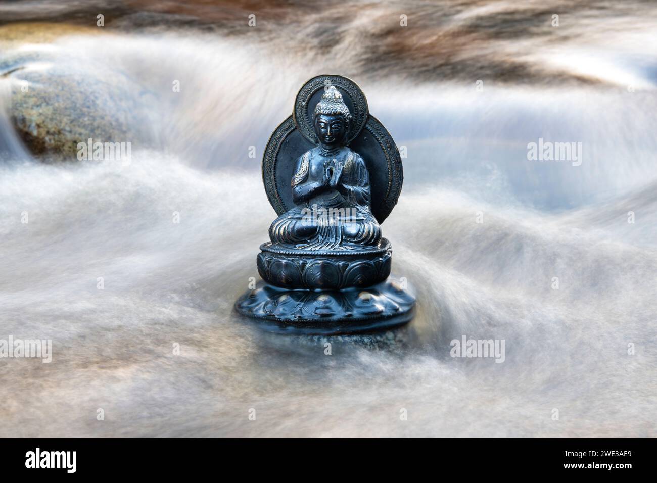 Statua del Buddha tra le rapide acque del fiume Findhorn. Morayshire, Scozia Foto Stock