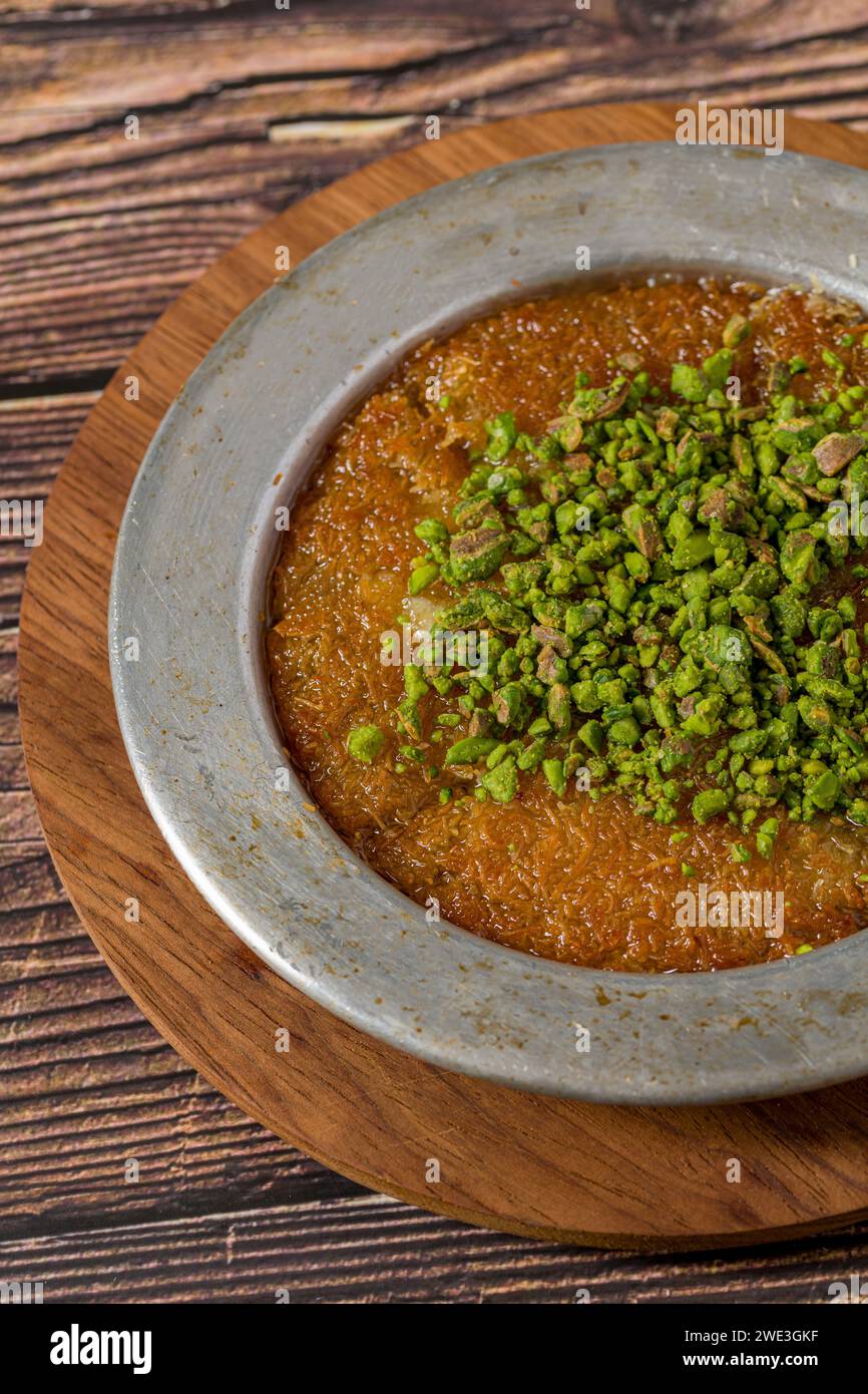 Dessert turco tradizionale kunefe al pistacchio su un tavolo di legno Foto Stock