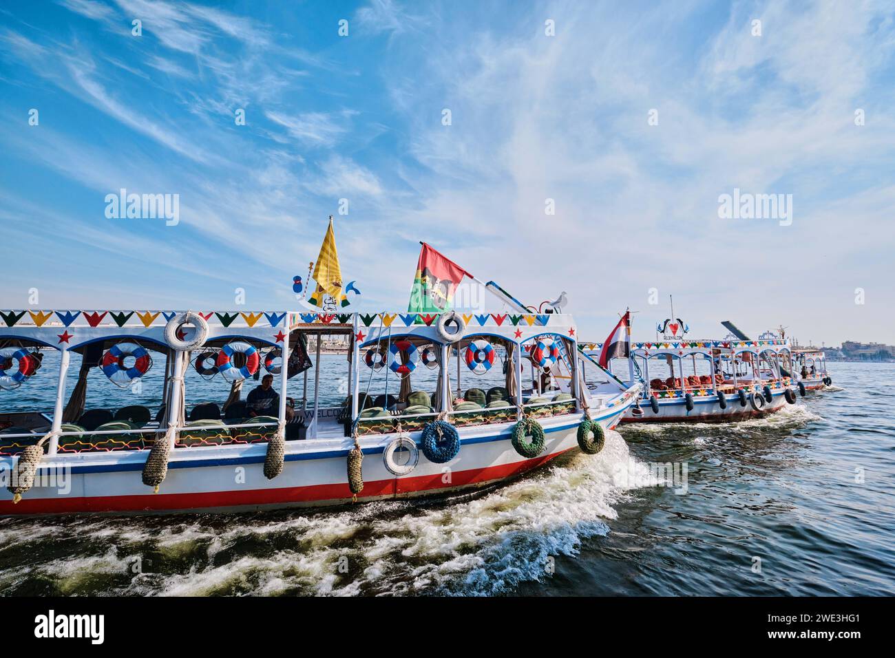 Luxor, Egitto - dicembre 26 2023: Barche a motore per attraversare il Nilo dall'altra parte, trasporto fluviale ornato Foto Stock