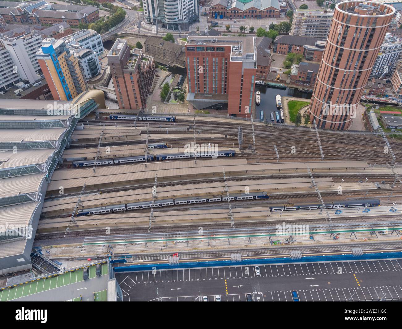 Immagine aerea di piattaforme, binari, linee e treni alla stazione di Leeds, con Candle House e Granary Wharf nel centro di Leeds, Yorkshire, Regno Unito Foto Stock