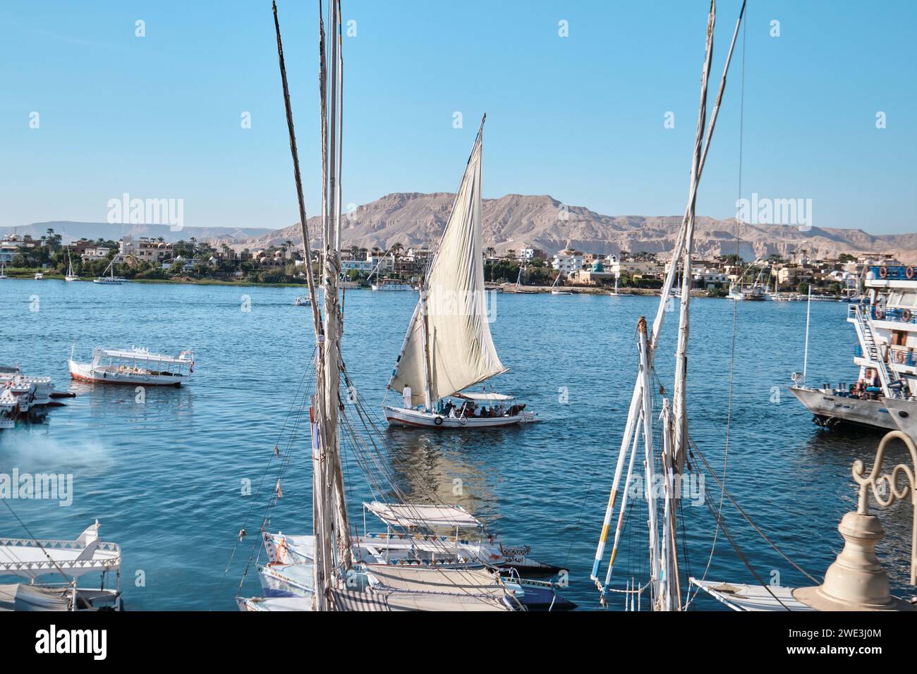Luxor, Egitto - dicembre 26 2023: Barca tradizionale e una Felucca che naviga lungo il Nilo Foto Stock