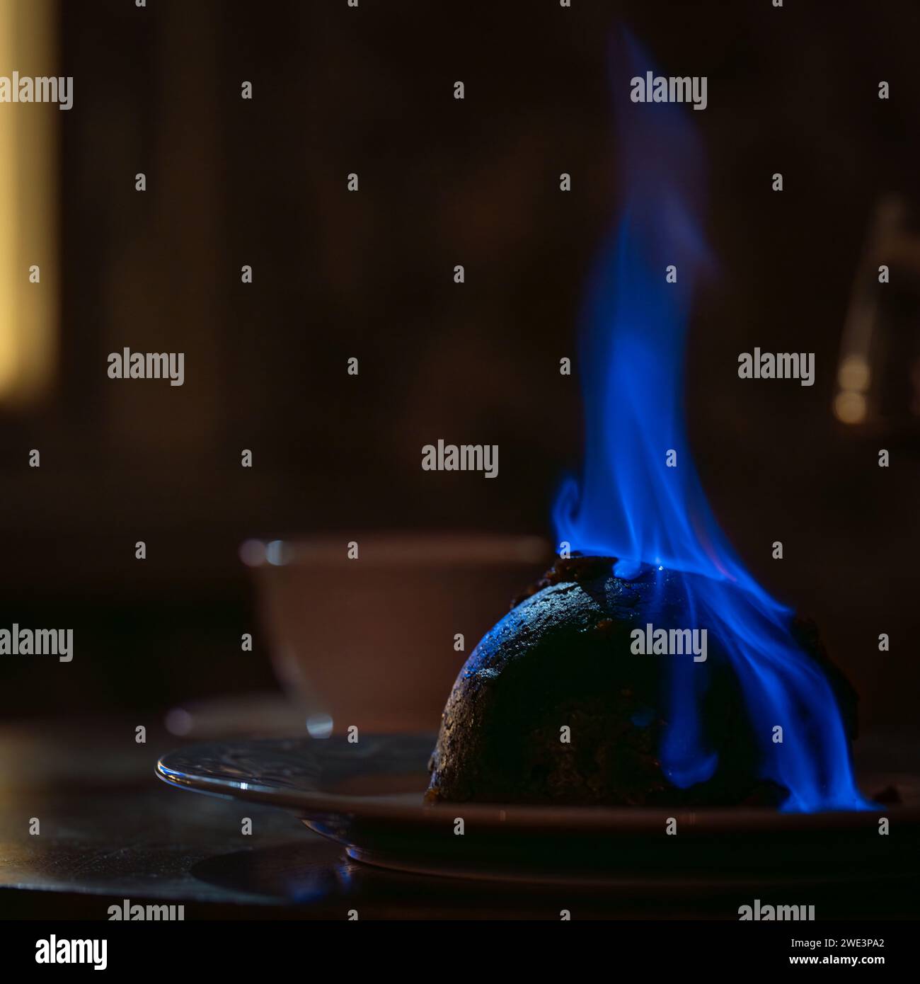 Pudding natalizio incendiato. Budino di Natale inglese fiammeggiante. Messa a fuoco morbida. Foto Stock
