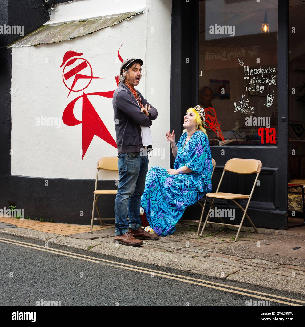 Un uomo e una donna che chiacchierano in una strada di Devon, regno unito Foto Stock