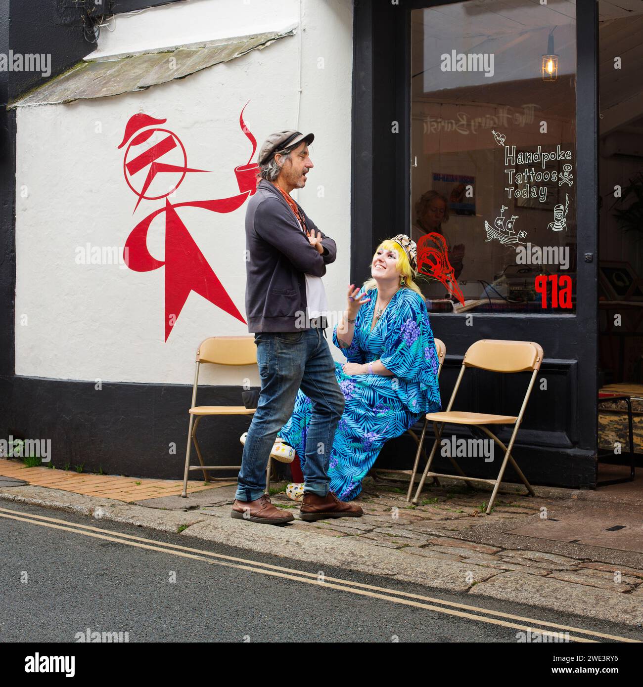 Un uomo e una donna che chiacchierano in una strada di Devon, regno unito Foto Stock