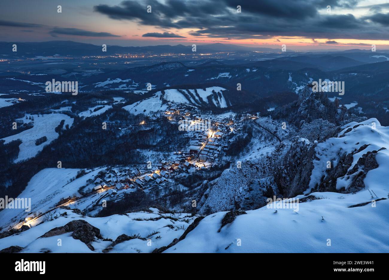 Villaggio di montagna invernale dei Carpazi in luce con case di legno su una collina ricoperta di neve fresca. Foto Stock