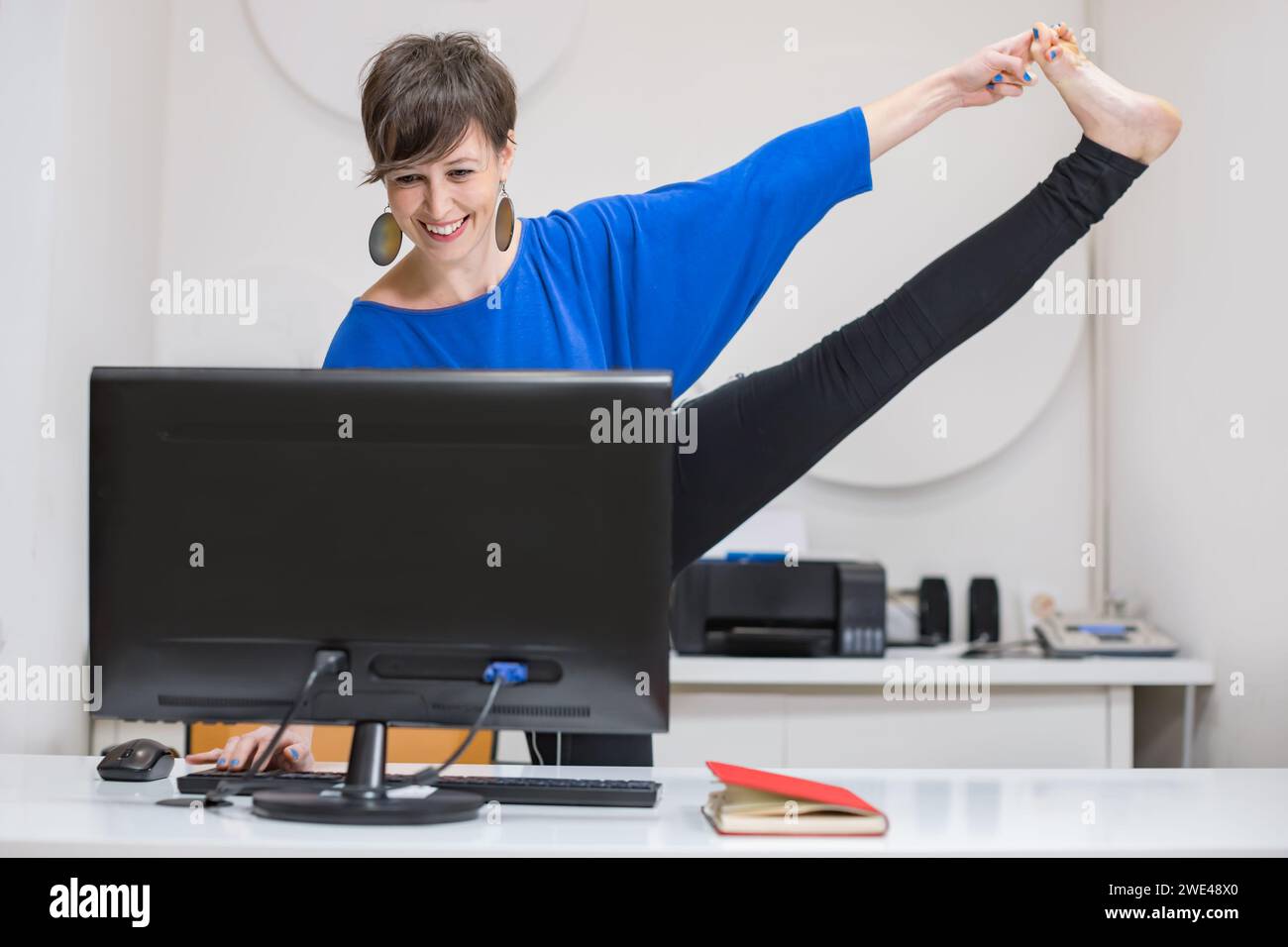 giovane donna che pratica yoga in ufficio Foto Stock
