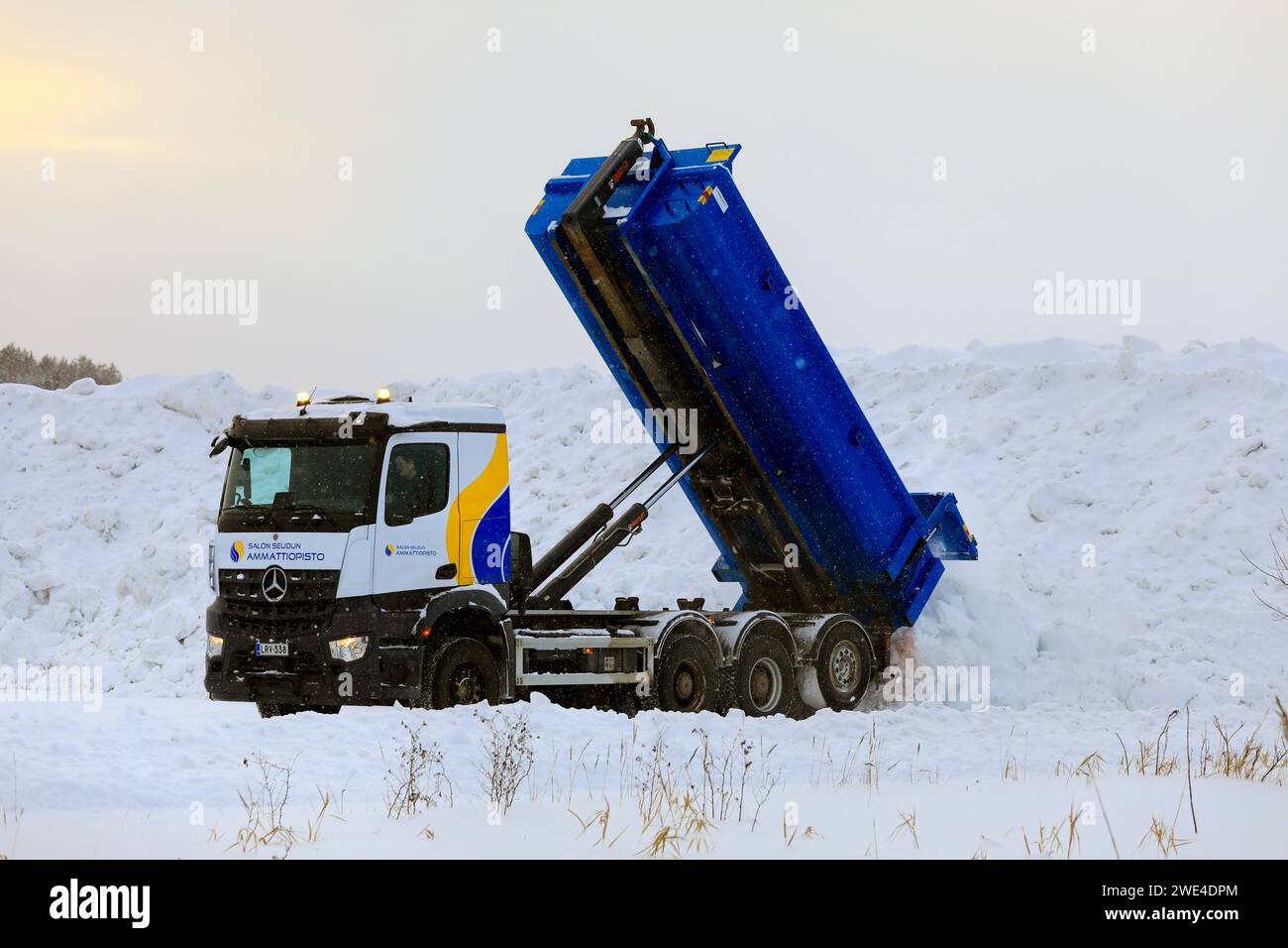 Il veicolo ribaltabile Mercedes-Benz scarica la neve pulita dalle strade e dai parcheggi nell'area di scarico della neve municipale. Salo, Finlandia. 19 gennaio 2024. Foto Stock
