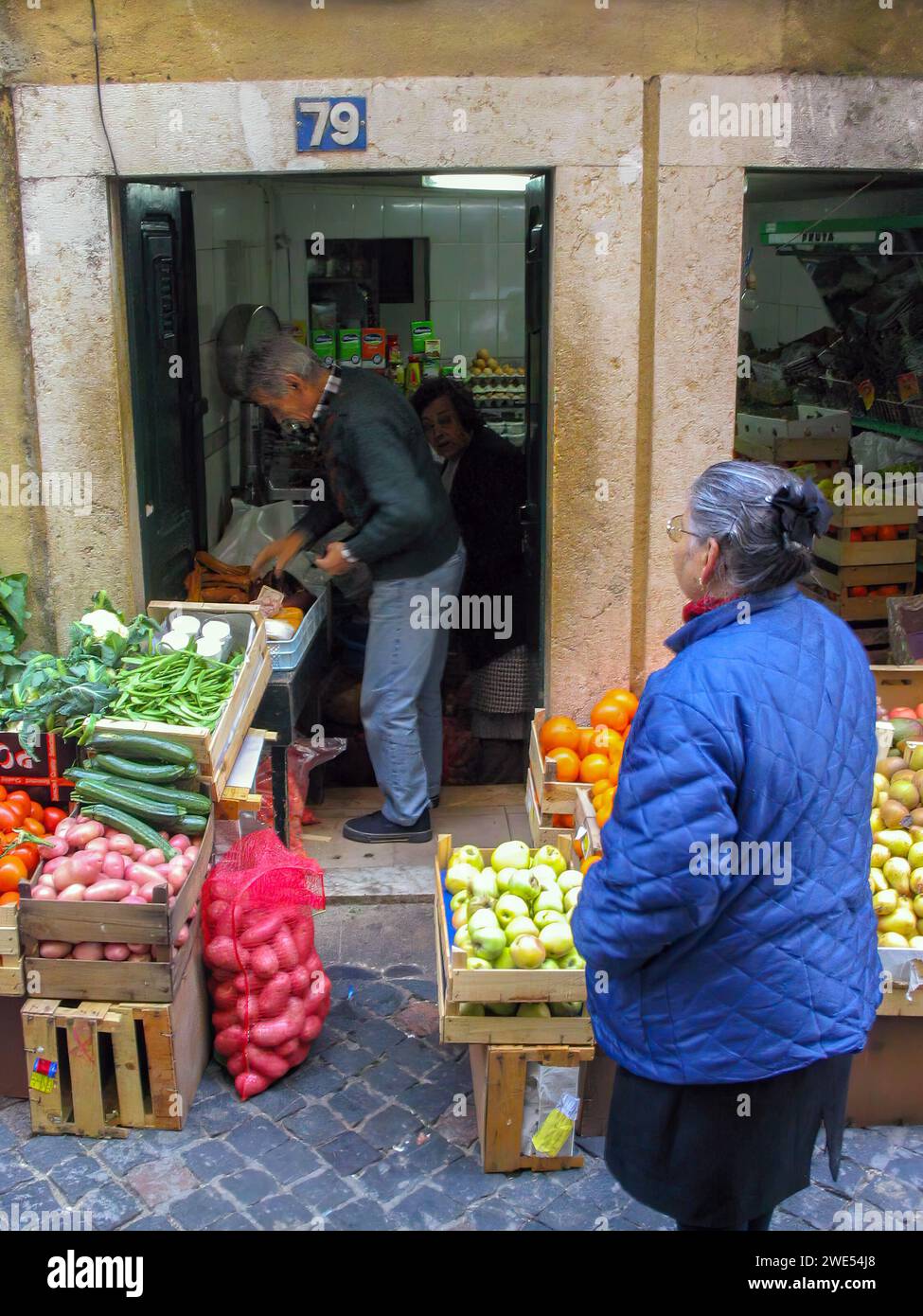 Lisbona, Portogallo: 10 novembre 2023: Alimentari e vecchi clienti in un piccolo negozio di alimentari tipico o tradizionale, con frutta e verdura in scatole Foto Stock