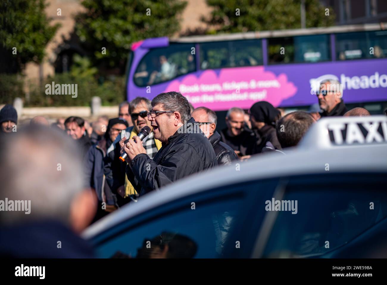 Roma, RM, Italia. 23 gennaio 2024. I tassisti protestano contro l'amministrazione del comune di Roma che non aggiorna le tariffe dei taxi con l'aumento del costo della vita e il mancato rispetto delle regole da parte di quei conducenti che operano senza patente di taxi. Il rappresentante sindacale parla con la folla. (Immagine di credito: © Marco di Gianvito/ZUMA Press Wire) SOLO USO EDITORIALE! Non per USO commerciale! Foto Stock