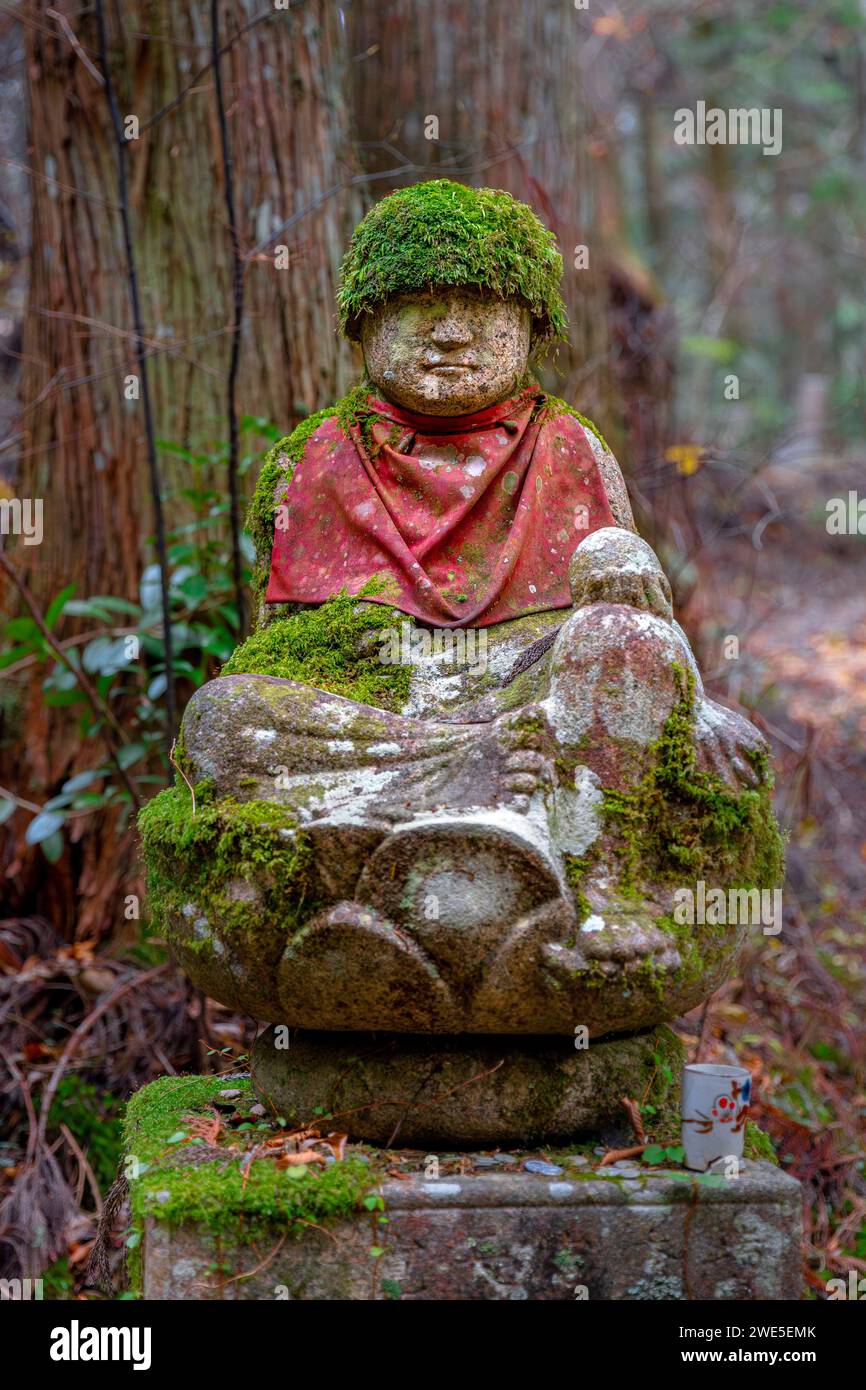 Statua con cappello commemorativo in pietra all'interno del cimitero Okunoin Koyasan Foto Stock