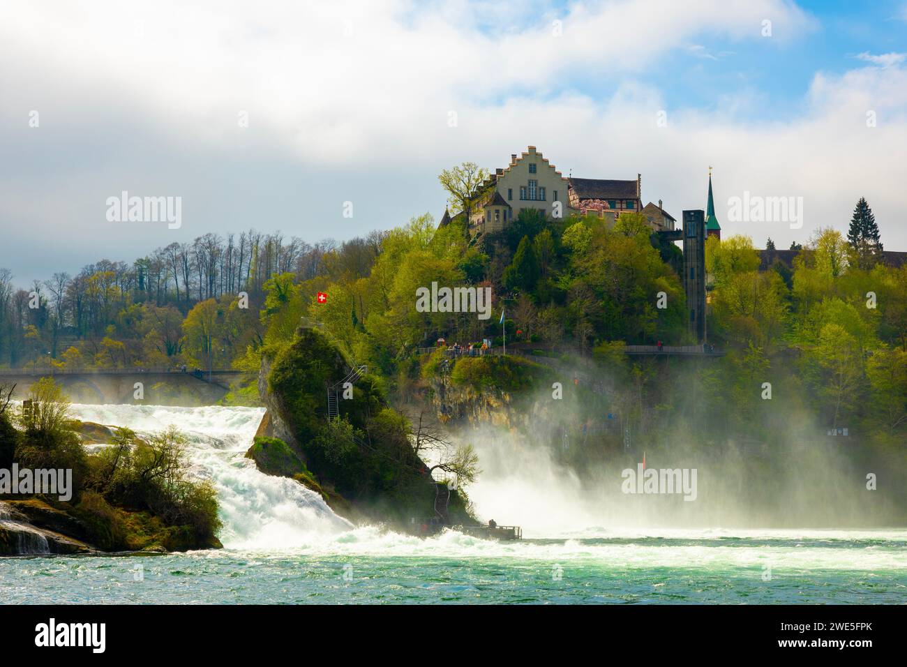 Cascate del Reno e bandiera svizzera con il castello Laufen a Neuhausen a Sciaffusa, Svizzera. Foto Stock