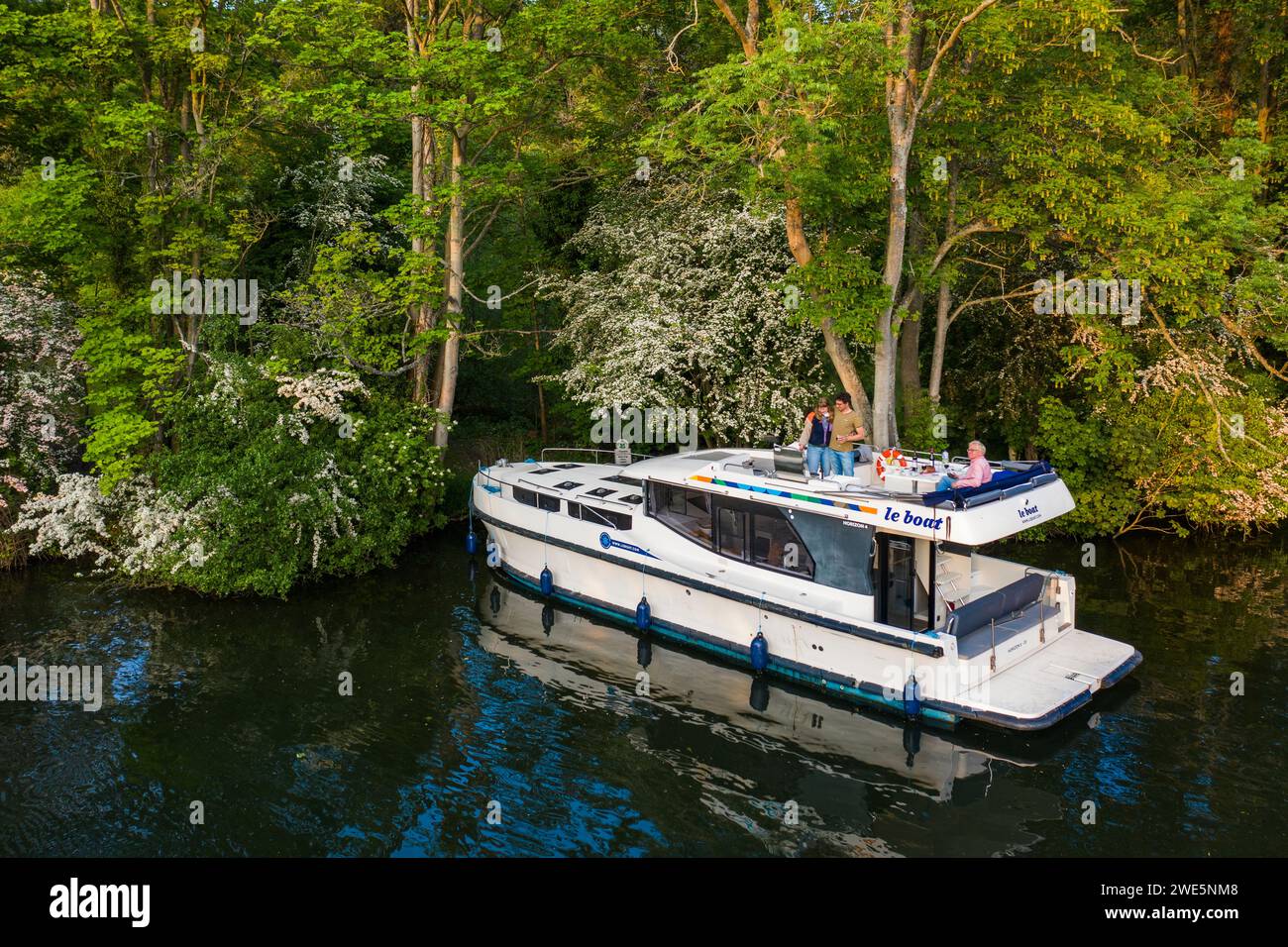 Vista aerea di una casa galleggiante le Boat Horizon 4 ormeggiata su un'isola sul Tamigi vicino al Cliveden National Trust, con persone che preparano un barbecue di Foto Stock