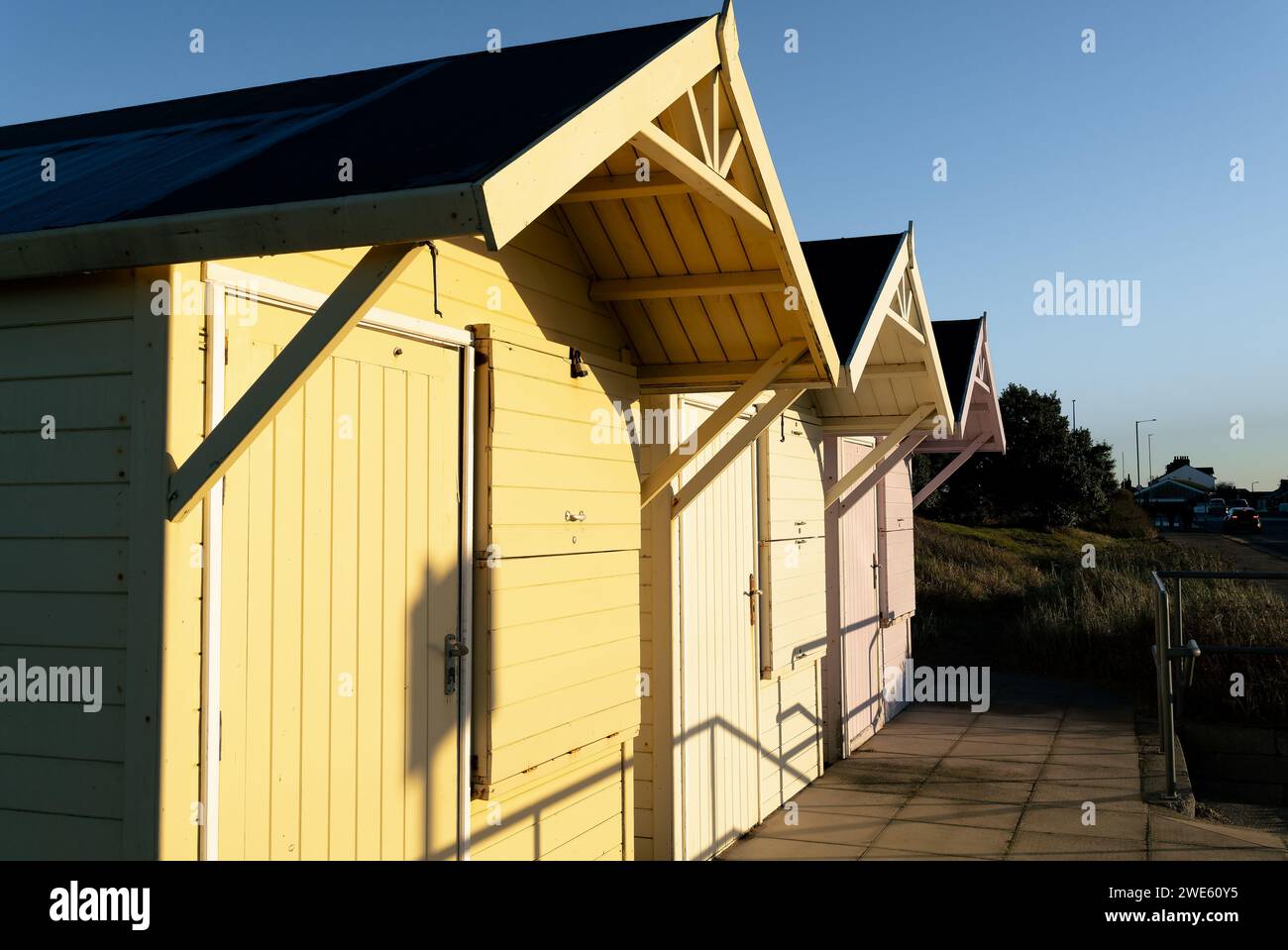 fila di capanne in legno dipinte in colori pastello sul mare Foto Stock
