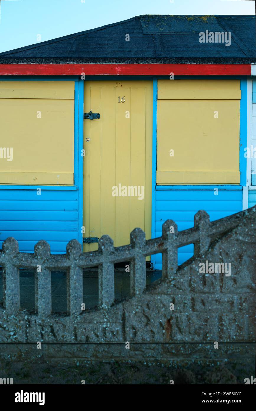 fila di capanne in legno dipinte in colori pastello sul mare Foto Stock