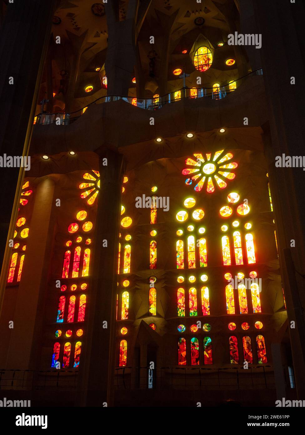 La luce del sole passa attraverso le vetrate colorate della basilica della Sagrada Familia Foto Stock