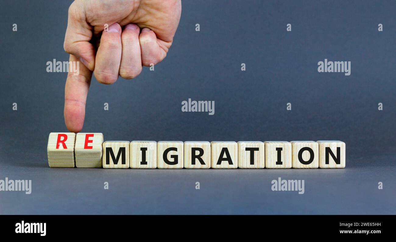 Simbolo di migrazione o di remigrazione. Concetto di Migration Remigration su bellissimi cubi di legno. Splendido sfondo grigio. Mano d'affari. M. Aziendale Foto Stock