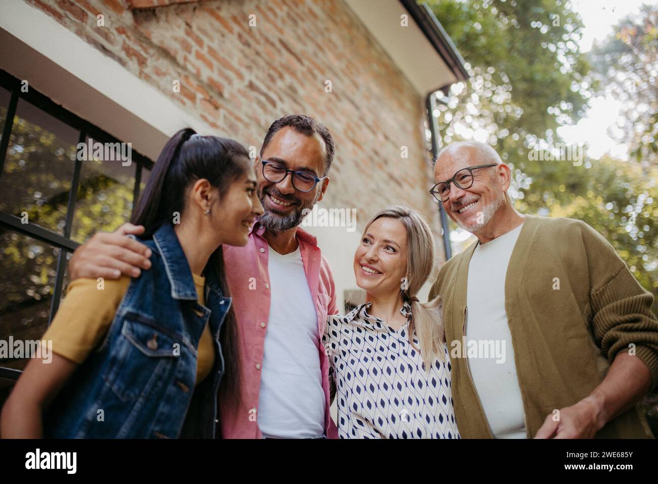 Persone che si riuniscono all'aperto che parlano con le braccia Foto Stock