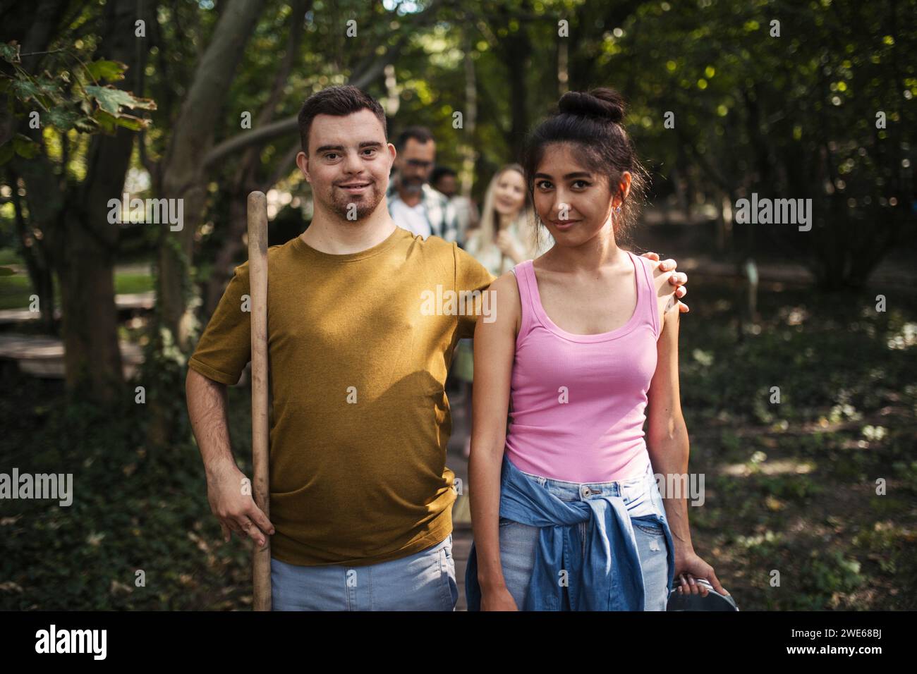 Giovane con sindrome di Down che partecipa alla pulizia della comunità con la sua amica Foto Stock