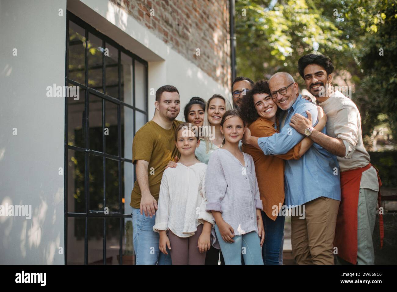Gruppo eterogeneo di membri della comunità che abbracciano un progetto comunitario di successo Foto Stock