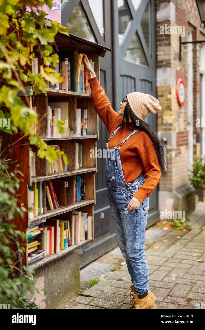Donna che cerca il libro alla stalla Foto Stock