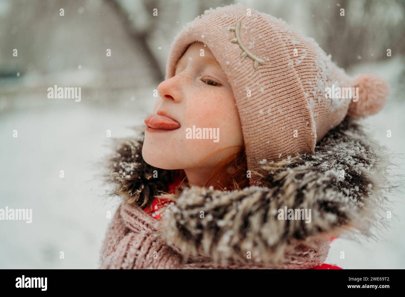 Ragazza che cattura la neve con la lingua in inverno Foto Stock