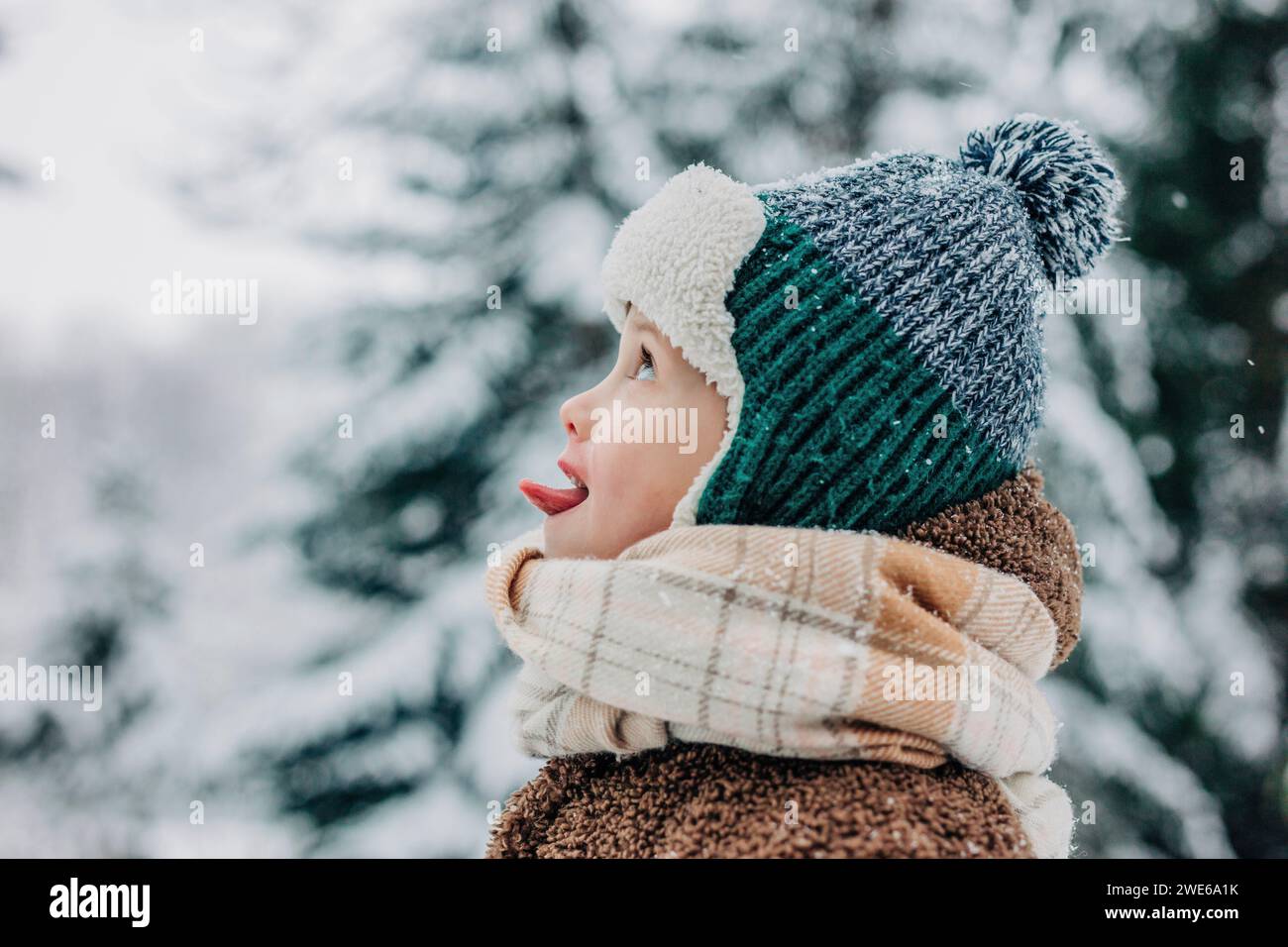Ragazzo carino che cattura la neve con la lingua in inverno Foto Stock