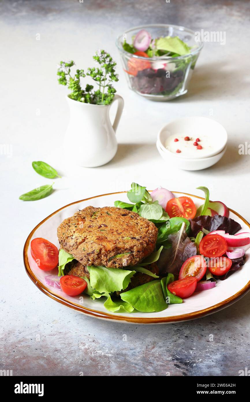 Hamburger con fagioli di mirtillo, zucchine e cipolle primaverili Foto Stock