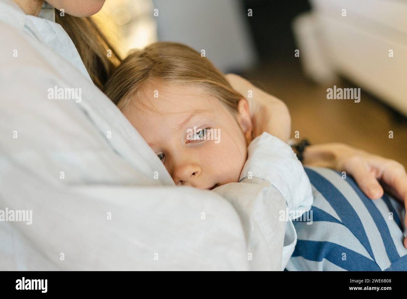 La madre abbraccia la figlia a casa Foto Stock