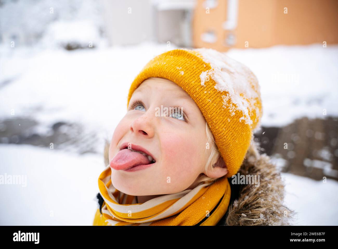 Ragazzo che cattura la neve con la lingua in inverno Foto Stock