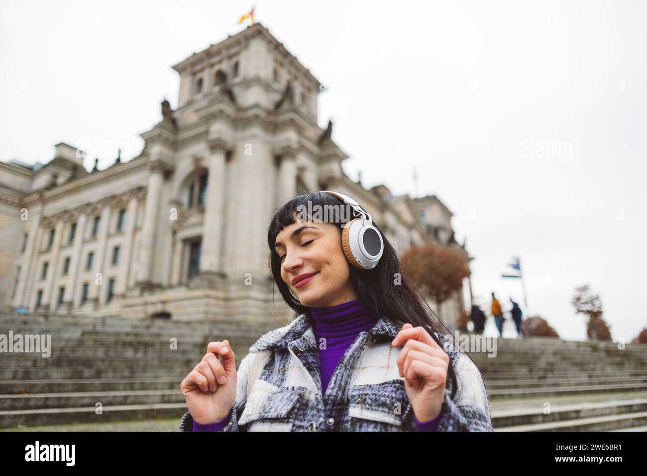 La donna sorridente ama ascoltare musica con le cuffie wireless Foto Stock