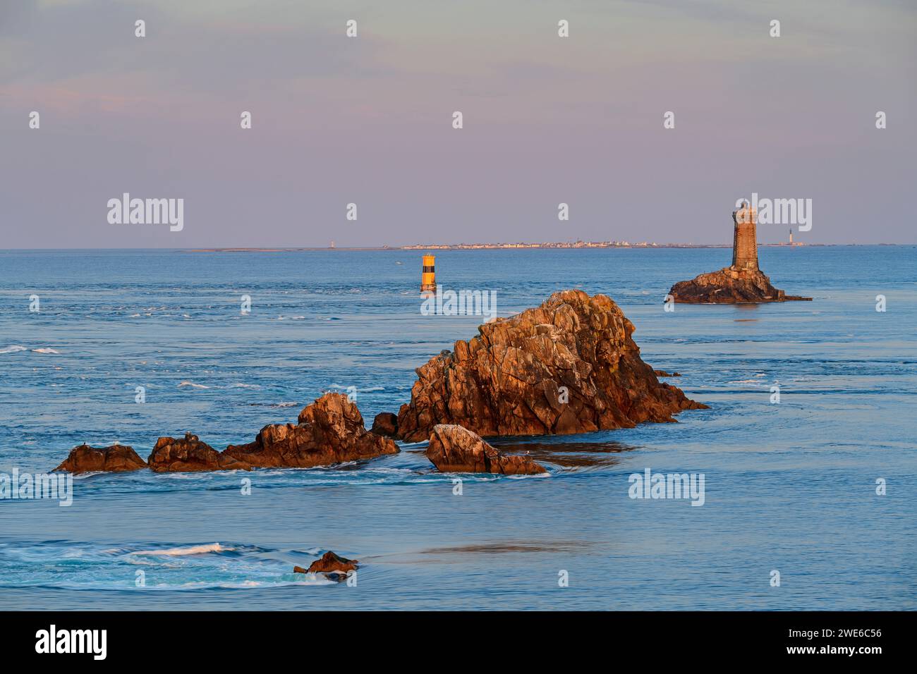 Francia, Bretagna, costa di Pointe du Raz con un piccolo faro sullo sfondo Foto Stock