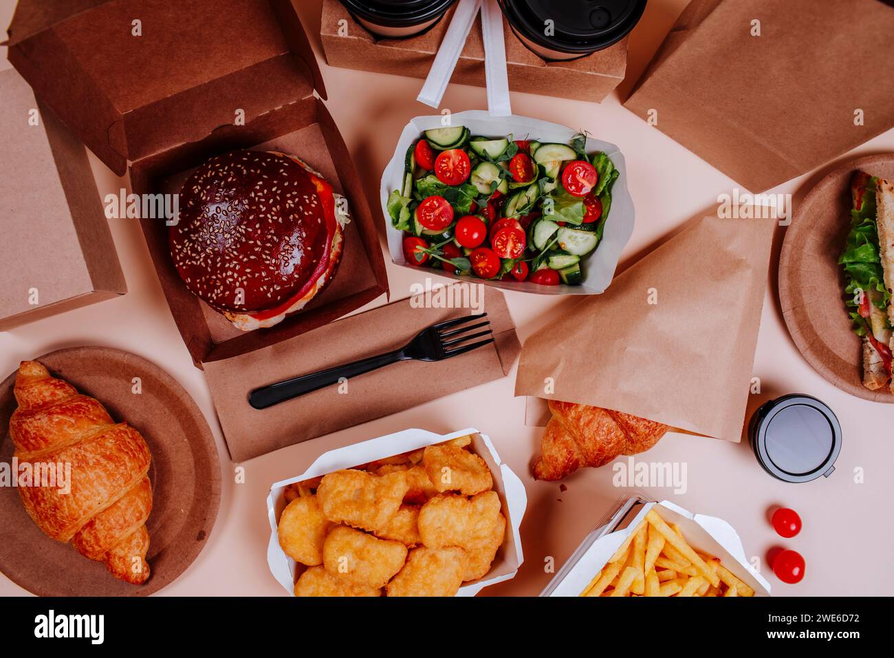 Insalata e fast food su sfondo beige Foto Stock