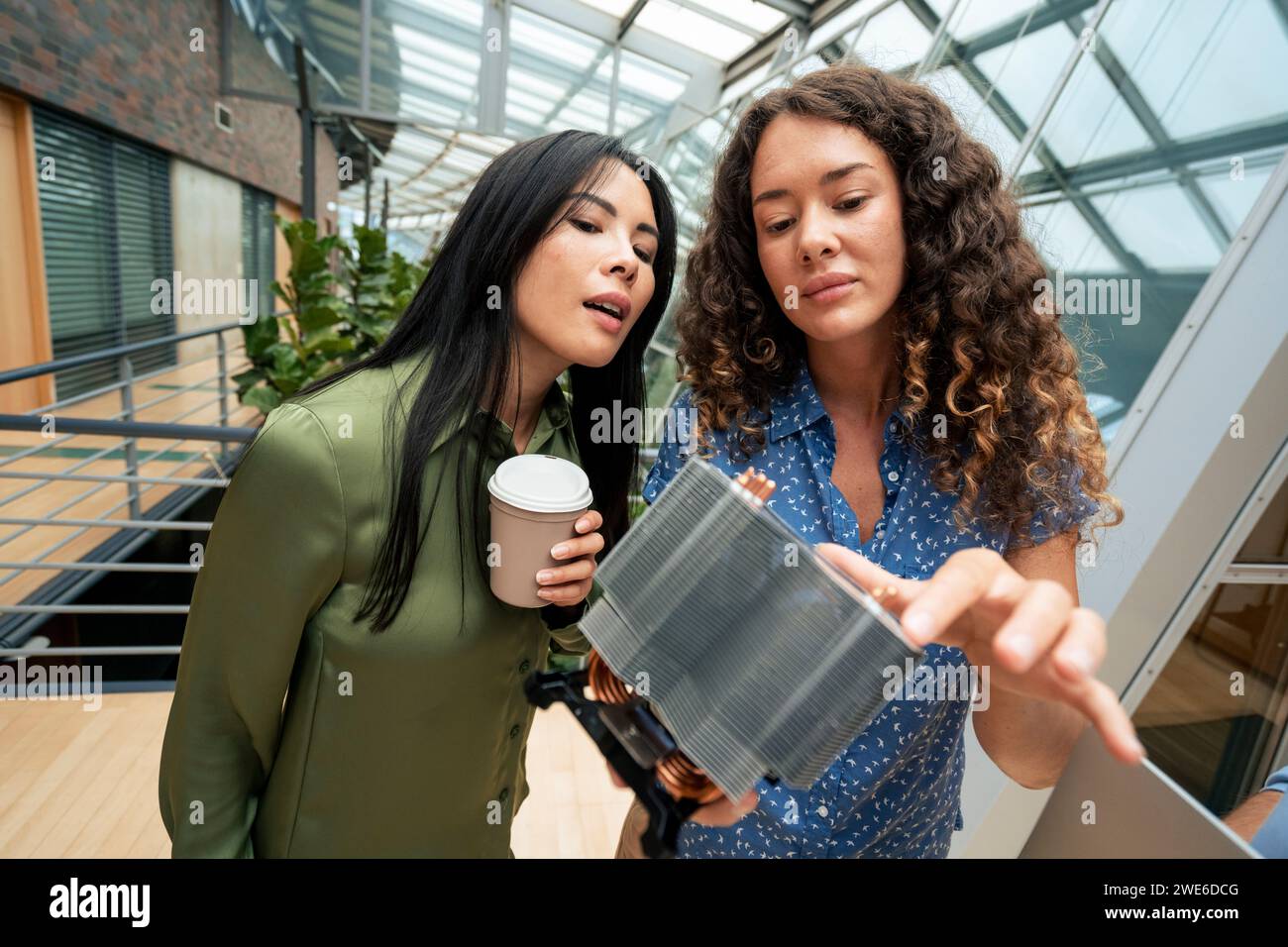 Tecnico che discute di una parte della macchina con un collega nel corridoio Foto Stock