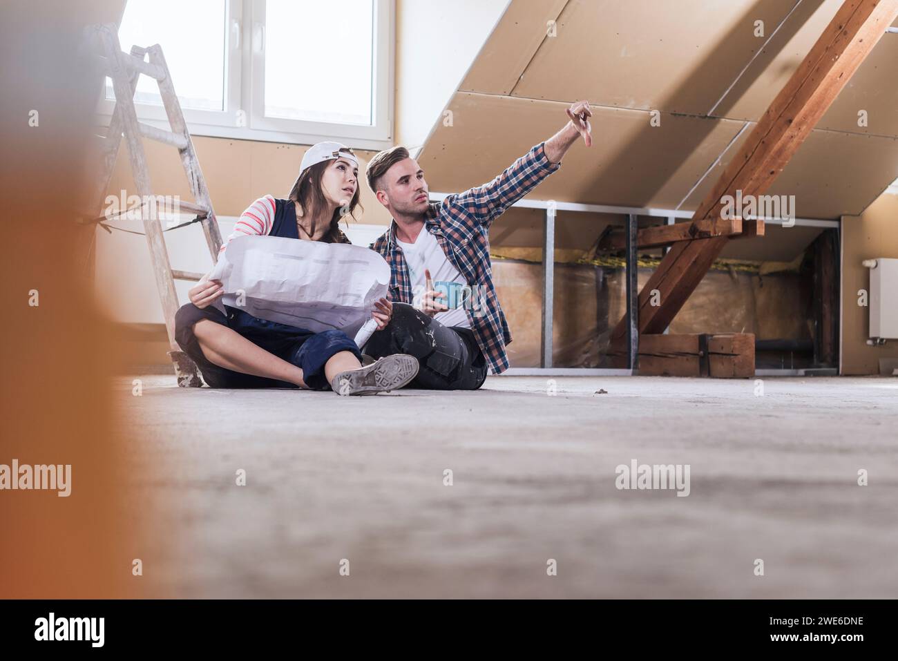 Donna che ha un progetto e pianifica con l'uomo per lo sviluppo domestico Foto Stock