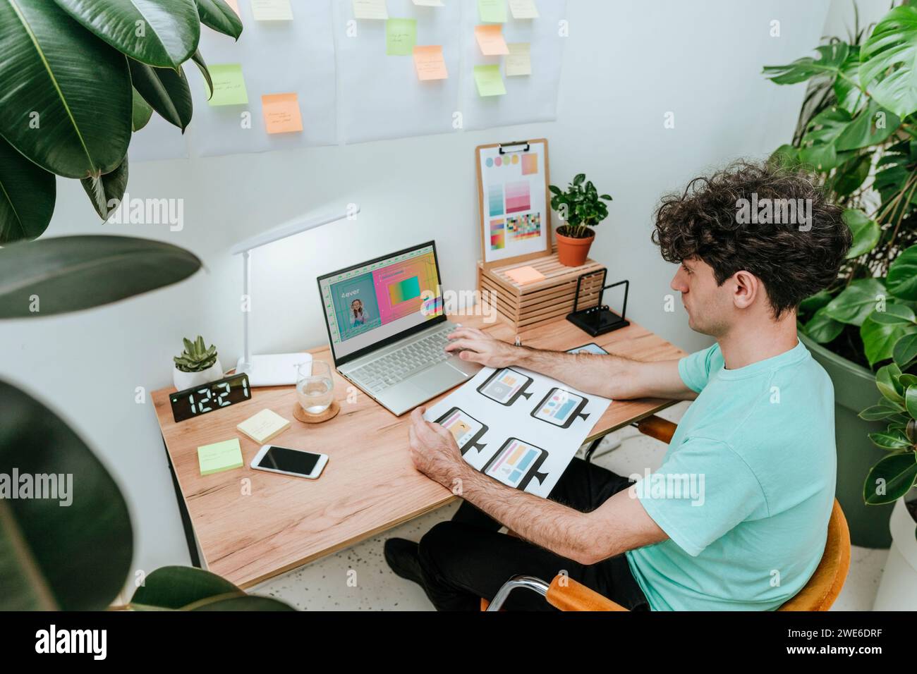 Web designer che lavora con documenti e laptop in ufficio Foto Stock