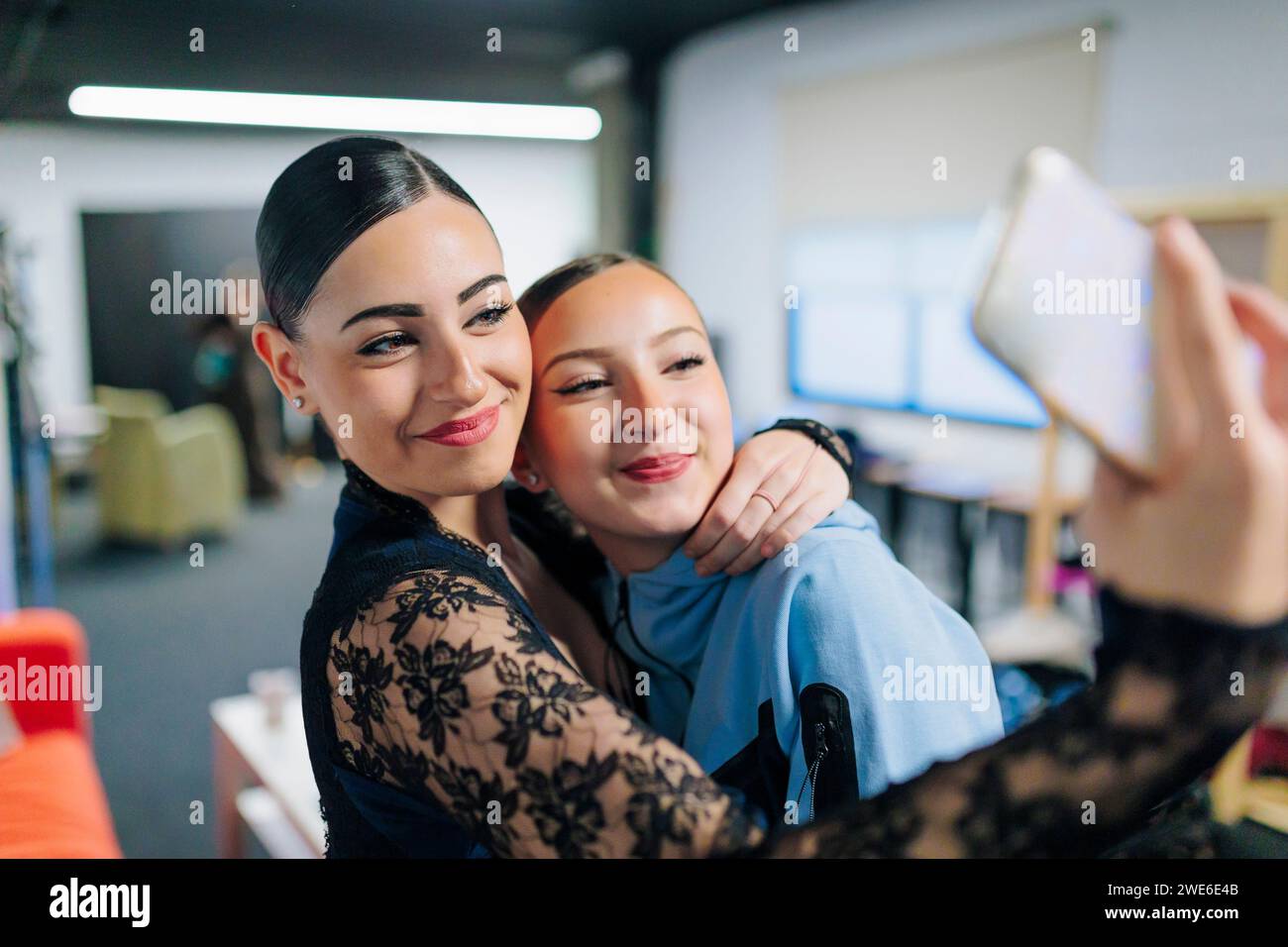 Donne sorridenti che scattano selfie tramite smartphone in studio di danza Foto Stock