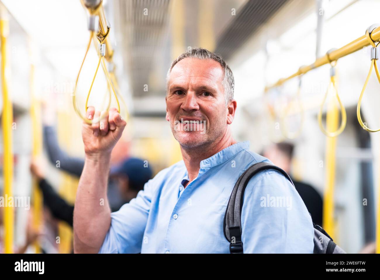 Un sorridente uomo d'affari che viaggia in treno Foto Stock