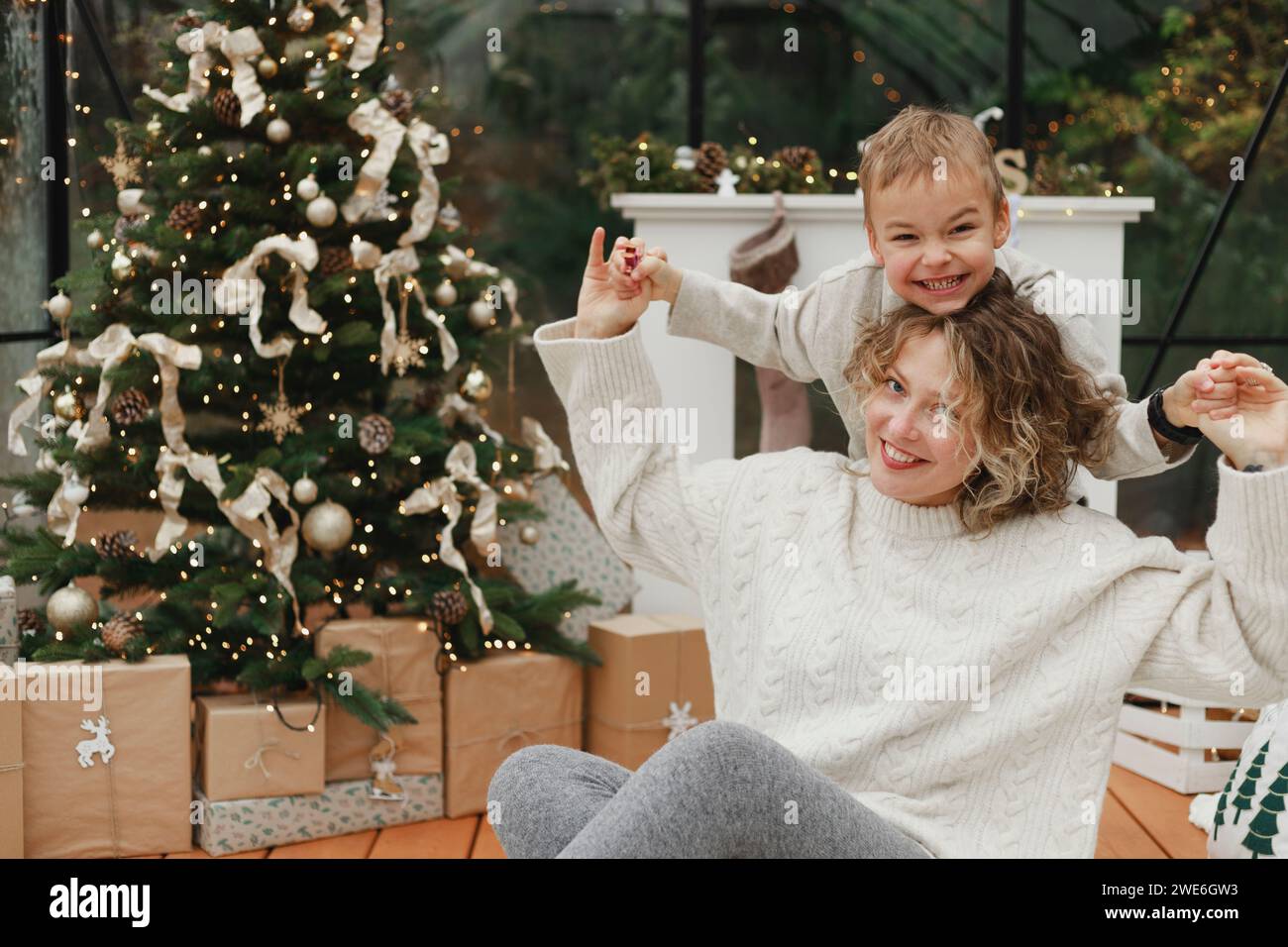 Madre e figlio felici che si divertono vicino all'albero di Natale a casa Foto Stock