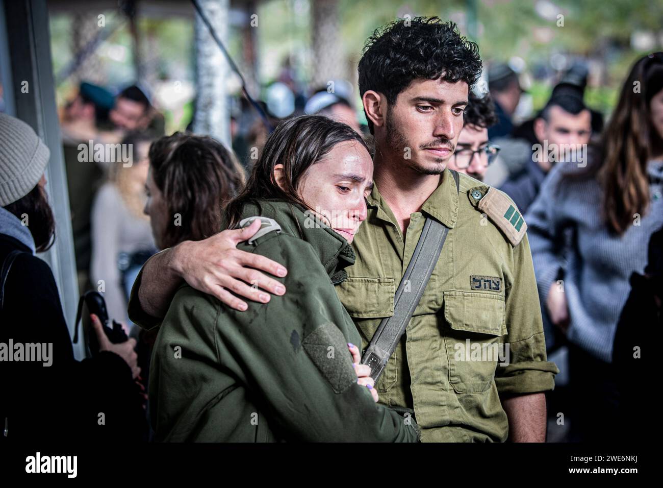 I soldati israeliani si confortano a vicenda durante la cerimonia funebre del maggiore, Ilay Levi, al cimitero militare di Tel Aviv. Il maggiore, Ilay Levi, 24 anni, è stato ucciso in battaglia nella Striscia di Gaza meridionale. Ventiquattro soldati israeliani sono stati uccisi a Gaza lunedì, di gran lunga il maggior numero di vittime israeliane in un solo giorno nei tre mesi di guerra contro Hamas, mentre i discorsi su un cessate il fuoco si intensificavano e le vittime palestinesi continuavano a salire.le morti sono avvenute tra feroci combattimenti intorno alla città meridionale di Khan Younis, con decine di palestinesi uccisi e feriti. È probabile che le vittime israeliane aumentino le pr interne Foto Stock