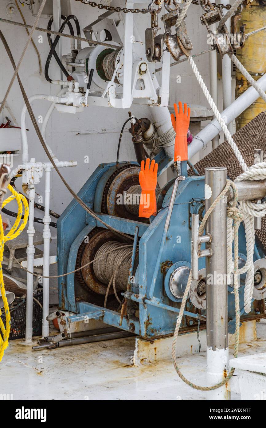 Guanti di gomma che si asciugano sulle maniglie del verricello di un peschereccio commerciale attraccato al porto di Long Beach, Mississippi Foto Stock
