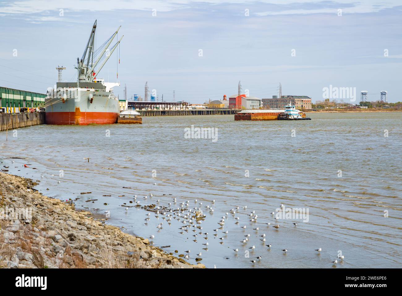 Nave cargo attraccata e un rimorchiatore che spinge una chiatta sul fiume Mississippi a New Orleans, Louisiana Foto Stock