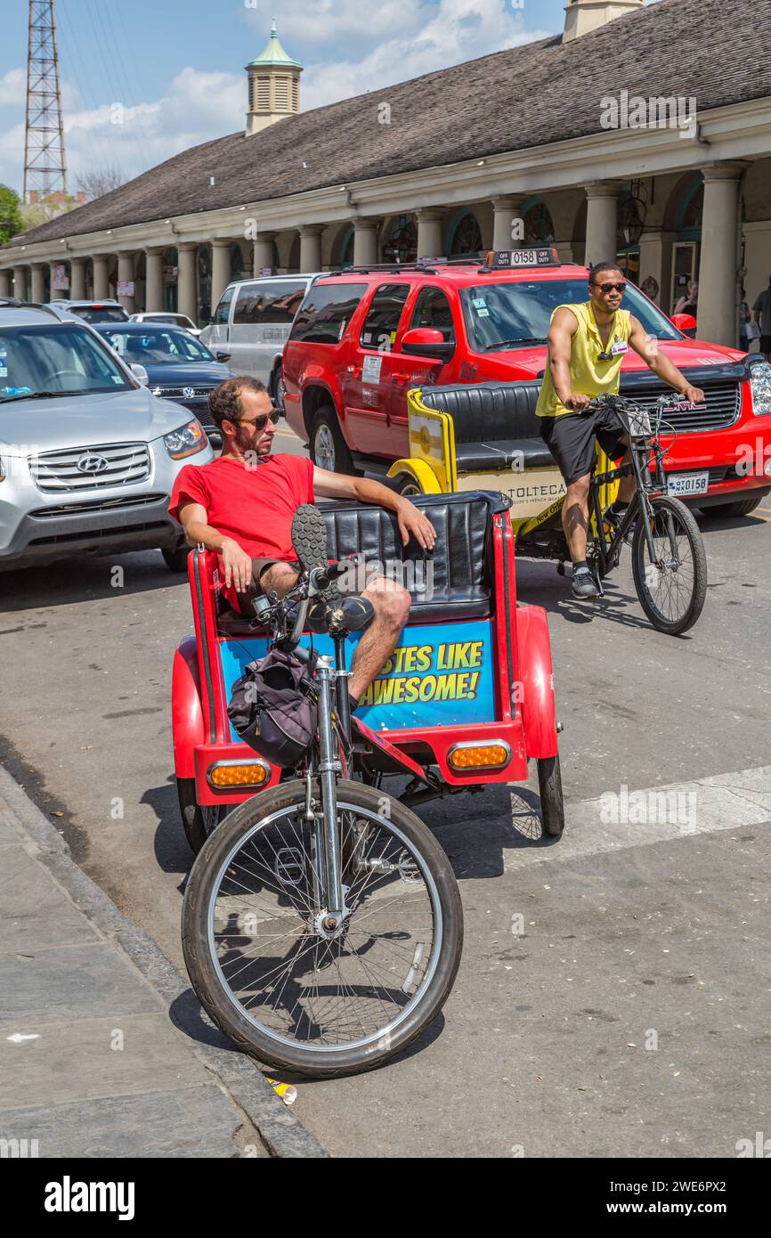 Autista di taxi in bicicletta che aspetta i passeggeri di fronte al mercato francese in Decatur Street nel quartiere francese di New Orleans, Louisana Foto Stock