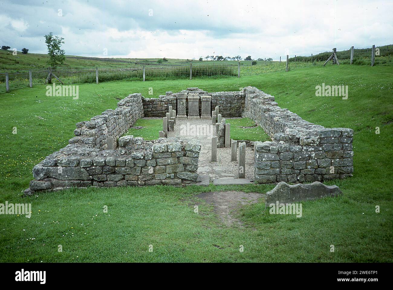 Questa foto del 1987 mostra il Tempio di Mitra in Inghilterra, lungo il muro di Adriano. Il forte romano di Carrawburgh è uno dei 16 forti lungo il Vallo di Adriano lungo 73 miglia, che fu iniziato intorno al 122 d.C. Carrawburgh ospitava una guarnigione di circa 500 soldati. I loro ordini erano di difendere la frontiera dell'Impero Romano. Nelle vicinanze si trova il tempio dedicato al dio Mitra, costruito dai soldati di Carrawburgh. Mitraism era una religione romana ispirata da un dio originariamente venerato nell'Impero orientale. Secondo la leggenda, Mitra, un dio guerriero persiano, catturò e uccise un toro sacro in una grotta, che templi mitraici Foto Stock