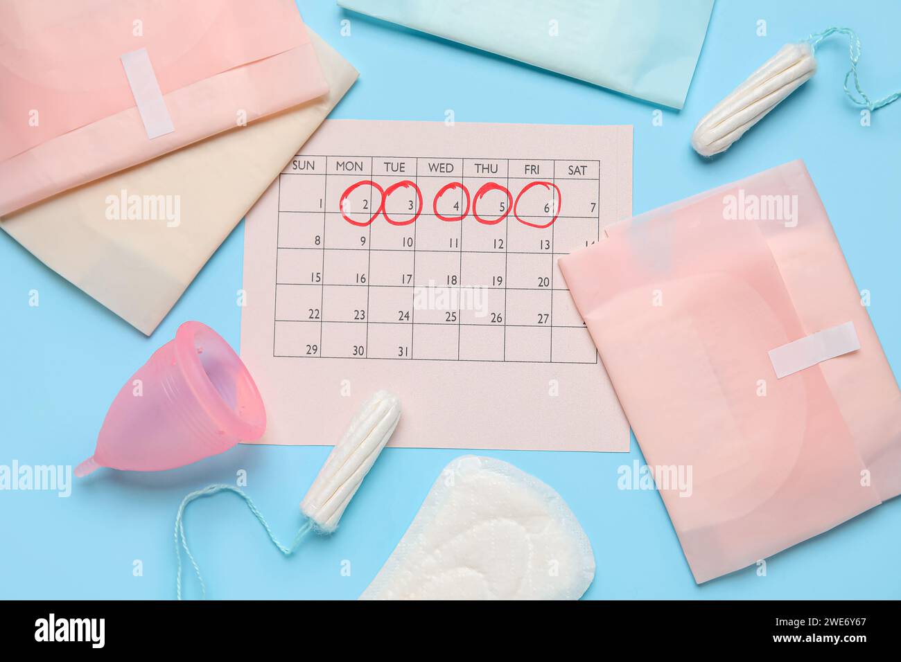 Composizione con calendario mestruale e prodotti per l'igiene femminile su sfondo colorato Foto Stock